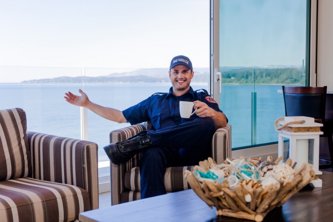 Hometown Heroes Lottery spokesperson Sebastian Sevallo enjoys a coffee on the deck of this year’s Grand Prize home in Sooke, a 3-bedroom ocean view Yacht Suite.